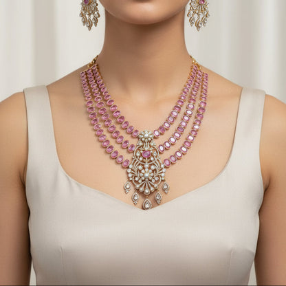Jewelry set with pink gemstones and gold accents on a black background